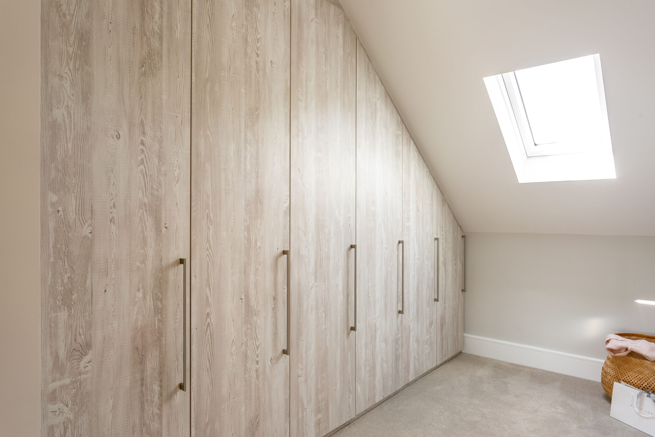Angled six-door hinged wardrobe fitted into a sloped ceiling
